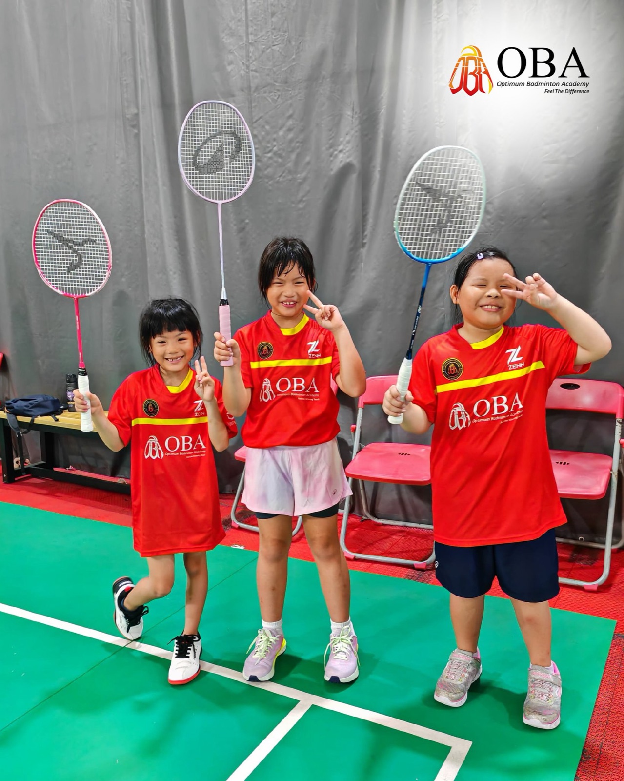Three campers giving peace signs with their rackets raised