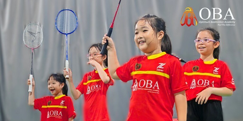 Four campers raising their rackets together