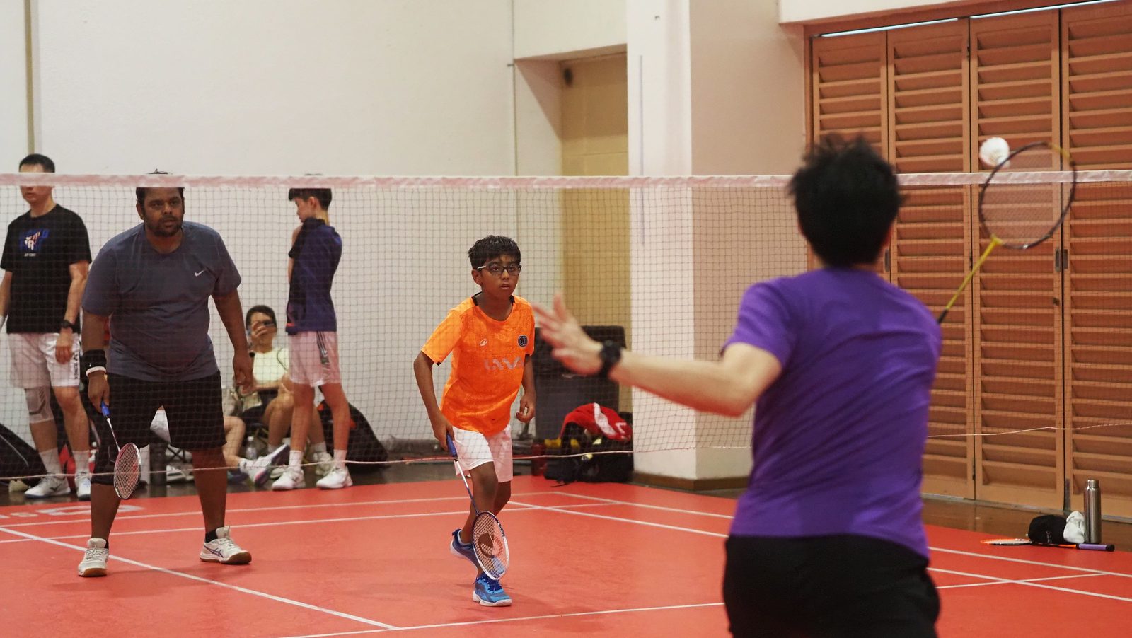 A junior shaking hands at the net after a match