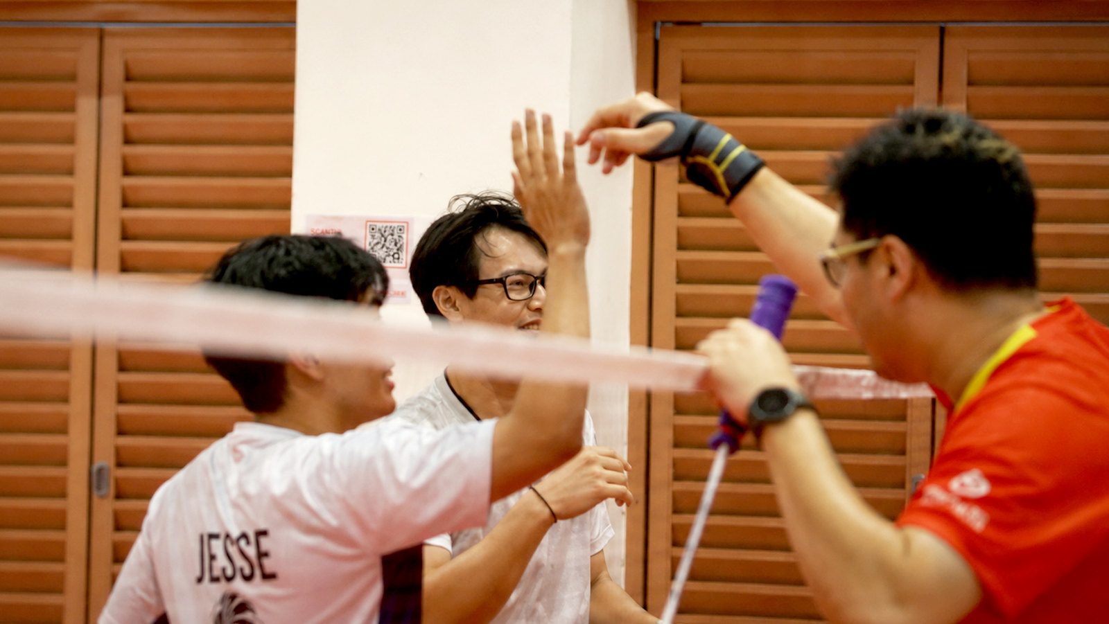 Players giving a high five over the net after a point